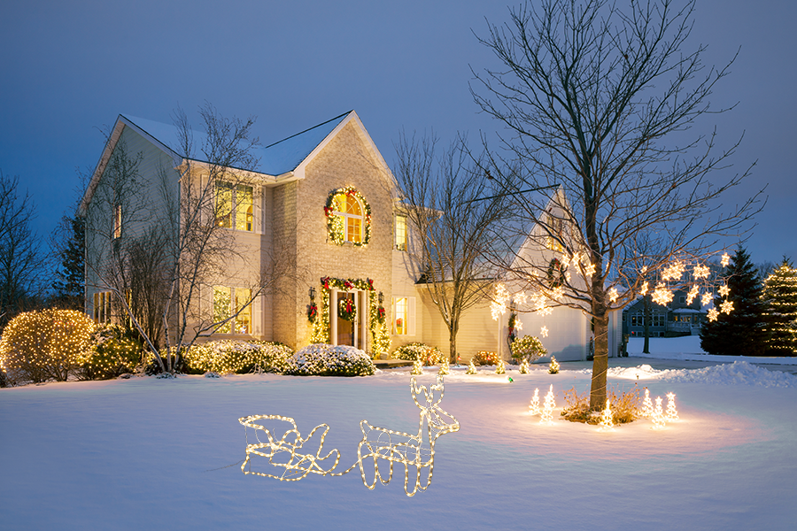 rendier met slee verlicht voor huis met sneeuw