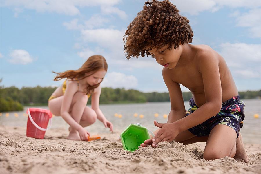 Jongen en meisje aan het spelen in het zand