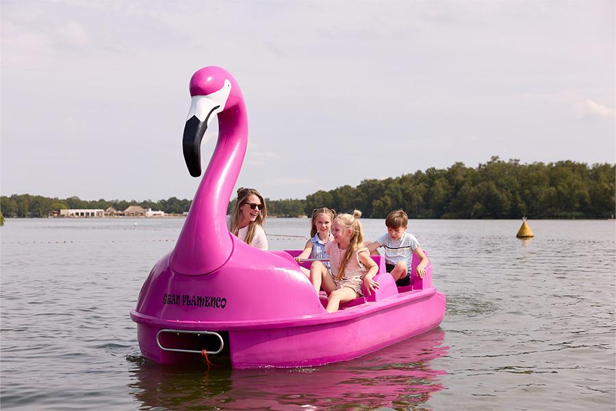 Waterfiets in de vorm van een flamingo met gezin er in